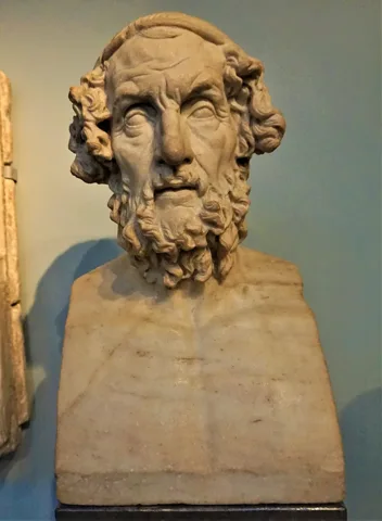 British Museum'daki “Homeros portre büstü” (30 Ağustos 2018 tarihli fotoğraf). Homeros'un yaşadığı dönemde yapılmış bir portresi bilinmemektedir; kaynaklar şairin kimliğini bile tartışmalı sayar, bu nedenle büst gerçek bir portre değil, sonradan yapılmış bir betimlemedir.
