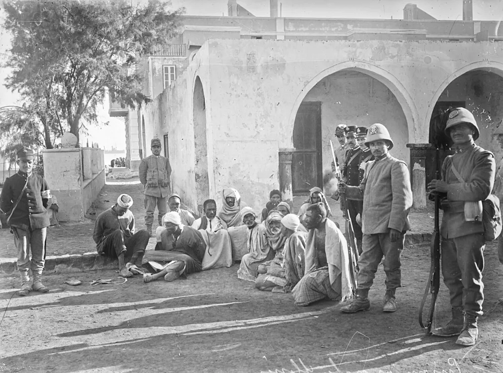 1911 tarihli bir basın fotoğrafı. Fransız Ulusal Kütüphanesi'nin konu kaydı fotoğrafı Trablus, Osmanlı–İtalyan Savaşı, esirler ve İtalyan askerleriyle ilişkilendirir; hangi olayı gösterdiği kaynakta ayrıca belirtilmemiştir.